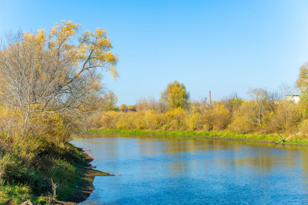 Experience the beauty of the changing seasons by the river Reflections of autumn foliage flicker on...