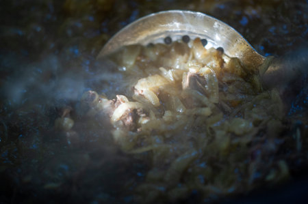 The traditional way of preparing pilaf with fried onions in a cauldron Gives the pilaf a rich and aromatic taste. Onions add depth and sweetness to the dish.の写真素材