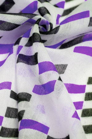 White silk fabric with purple and black geometric rhombus shapes. abstract drawing, closeup,...