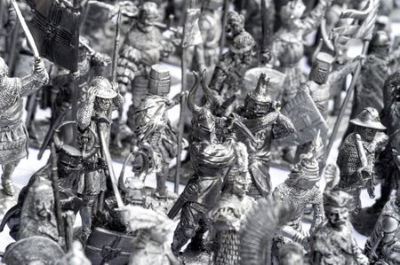 Dozens of intricately sculpted metal warriors from various eras engage in dynamic battle poses. Their ornate helmets, shields, and weapons create a captivating historical panorama.の写真素材