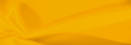 Undulating ripples flow across the golden cloth, casting playful contrasts of light and shadow. Subtle textures emerge, revealing a soft, warm, inviting aura in every crease.の写真素材