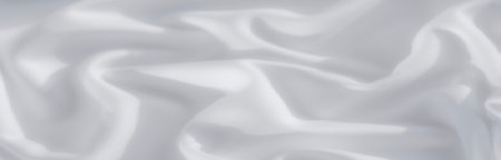 White fabric with delicate folds and soft light, creating a clean and minimal aesthetic. The play of shadows enhances its smooth, flowing texture.の写真素材