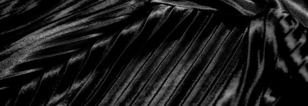 Black velvet fabric with delicate floral white embroidery and soft folds gives a tactile experience, merging elegance and artistry into a luxurious visual composition.の写真素材