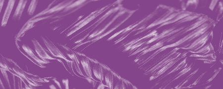 Close-up of fabric showcasing intricate embroidered details and flowing pleats. The soft light and...