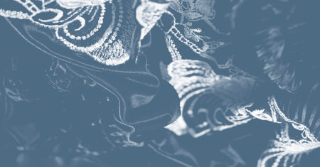 Overlapping patterns on textured fabric with intricate embroidery and decorative stitchwork create a...
