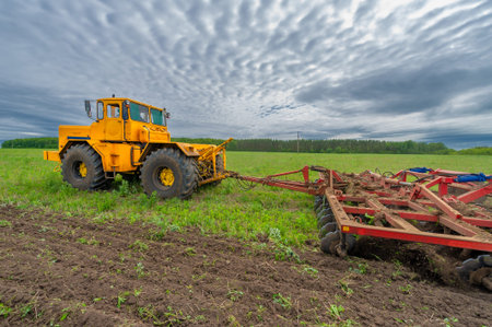 Spring photography, landscape with agricultural machinery, a tractor plows the land, plows a field,...