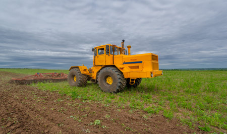 Spring photography, landscape with agricultural machinery, a tractor plows the land, plows a field,...