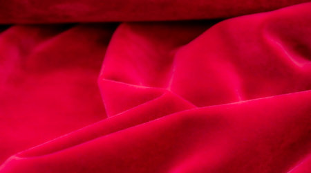 A series of photos featuring luxurious red velvet fabric, showing its rich texture and vibrant color. The fabric is draped and folded, highlighting its soft, plush, and elegant appearance.の写真素材