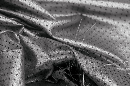 Fabric with a metallic sheen in small polka dots black A polychrome abstract pattern shimmers against a black sheer background with a space-age aesthetic giving this fabric a luxurious futuristic feelの写真素材