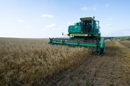 Summer photo of barley harvesting, Combine harvester, a machine commonly used for harvesting grain...