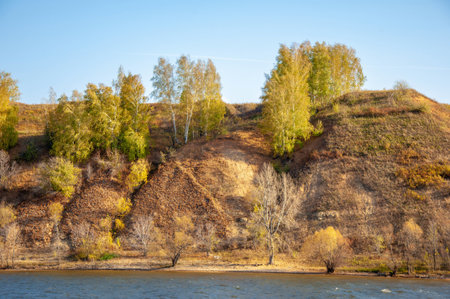 Autumn landscape banner, beautiful landscape with high river bank, reflection, blue sky and yellow sunlight at sunrise. The Kama river. Tatarstan. Russiaの写真素材