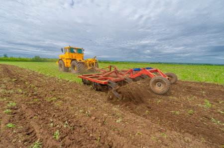 Spring photography, landscape with agricultural machinery, a tractor plows the land, plows a field,...