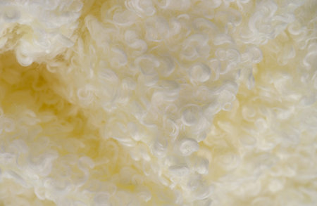 Faux fur of white pale yellow color. Imitation of karakul lamb skin. known as fleecy fabric, which...