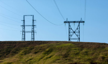 Autumn landscape, river, energy pillars, High voltage pole on blue sky backgroundの写真素材