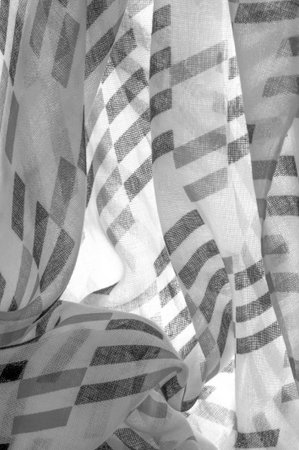 White silk fabric with black geometric rhombus shapes. dark. Background. Template.