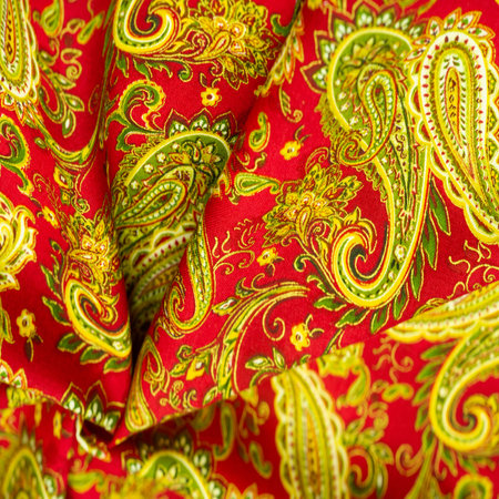 Paisley green pattern on a red background. decorated the bandanas of cowboys and bikers popularized...
