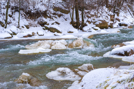 The river freezes in winter. My favorite winter river Silence in the forest was magical, broken only by the sound of the wind and the stream running, still alive, under the water. snow and iceの写真素材