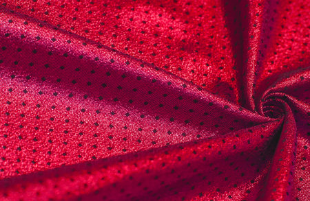 Fabric with a metallic sheen in small polka dots. Red burgundy. Always be a stunning ball champ with this stunning ruby metallic reversible heavy weight fabric.の写真素材