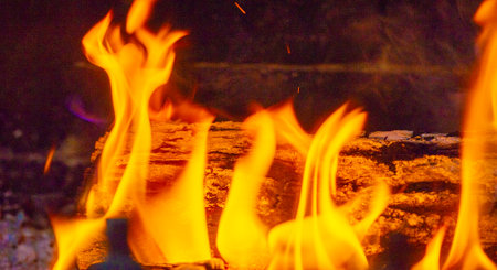Create a warm and cozy atmosphere with burning wood. The flame is bright and energetic. Adds warmth to any space. Enjoy the soothing crackle of wood.の写真素材