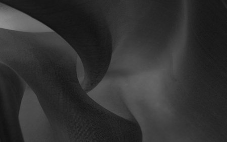 Blurred black silk fabric. Iridescent and shining like a star in the night sky, It has a taffeta-like body but a smooth surface that creates a subtle sheen.の写真素材