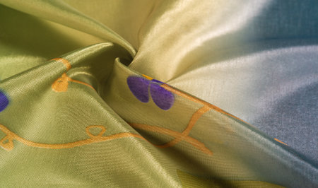 Background texture, silk fabric, shiny green light green color, with a small abstract print of rock paintings.の写真素材