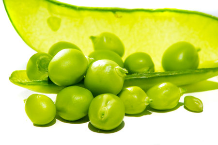 Aesthetic and visually appealing image with green peas on a white background Ideal for use in food design or advertising High quality and detailed photograph of fresh bright peasの写真素材