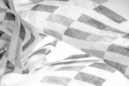 White silk fabric with black geometric rhombus shapes. dark. Background. Template.