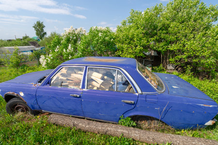 Spring photography, old car, firewood in the car protected from rainの写真素材