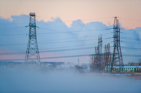 A beautiful and calm scene of a winter morning. High voltage power lines in foggy fog. Peaceful...