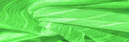 Silk fabric. Green wrinkled fabric texture. Green wrinkled, wavy surface texture. Close-up, soft...