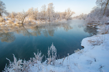 Enjoy the breathtaking beauty of a winter sunrise. Witness the perfect combination of warm and cool colors of nature. Take stunning photos of the sun reflecting on the icy river.の写真素材