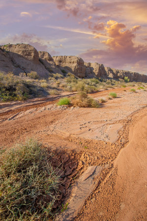 Enjoy the spectacular beauty of a mountain sunset. Witness nature's masterpiece as the sun sets over mountains of fiery red clay. Be captivated by the breathtaking colors and serene atmosphere.の写真素材