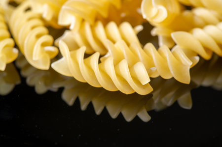 Delicious Italian wheat fusilli pasta is golden in color and perfect for a hearty lunch.の写真素材