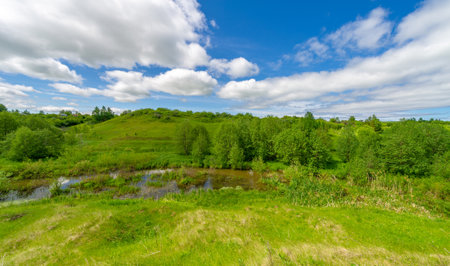 Spring, fields, ravines, hills, rural landscape. A deep, narrow gorge with steep slopes. A naturally raised area of ââland, not as high or craggy as a mountain.の写真素材