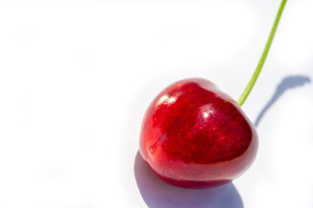 Fresh cherries on a white background create a bright and appetizing image. Rich in vitamin C and...