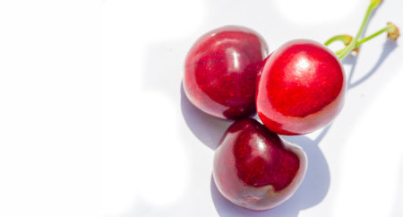 Juicy and ripe cherry on a white background. An excellent source of vitamins for a healthy lifestyle. Ideal for vegetarians looking for a nutritious snack.の写真素材