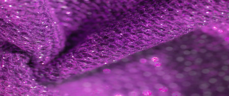 the purple glittering fabric texture with sparkling details creating a mesmerizing effect Soft folds and vibrant shine bring out a rich visual experience, perfect for abstract and textured backgroundsの写真素材