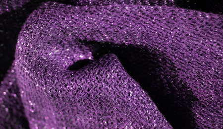 Blur this close-up image captures the intricate texture of a purple glittering fabric. The...