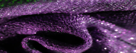 Blur vibrant purple fabric with glittering texture creates an intricate and dynamic surface. The shimmering details enhance the luxurious feel, making it visually captivating.の写真素材