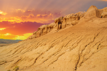 Enjoy a stunning sunset behind the Red Boguty Mountains. Immerse yourself in the beauty of nature's fiery masterpiece. Travel through the desert and make unforgettable memories.の写真素材