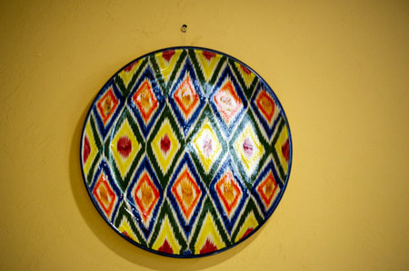 hand-painted clay plates depicting Uzbek culture. Vibrant colors and intricate patterns that capture the essence of Uzbek traditions. Ideal for serving food at cultural events and gatherings.の写真素材