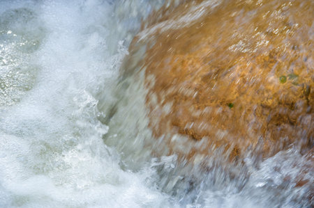 water in a mountain stream. breaks through the stones. Nature's Serenade: Just listen to the...