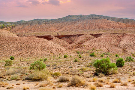 Experience the breathtaking beauty of the Red Boguty Mountains. Witness a majestic sunset that paints the sky in vibrant shades of orange and pink.の写真素材