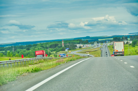 Enjoy a scenic drive through beautiful scenery. Experience the tranquility of nature as you travel along the highway. Admire breathtaking views of the majestic trees lining the road.の写真素材