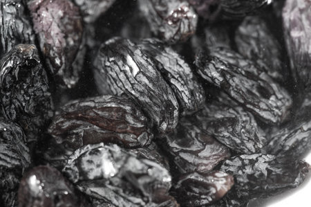 Enjoy the natural sweetness of black raisins in this close-up image that showcases their rich texture and flavor potential.の写真素材