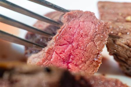 Raw beef steaks highlighted by a single sprig of fresh mint, placed on a textured surface, perfect for culinary concepts and food styling.の写真素材