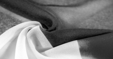 Treat yourself to a luxurious fabric with a sophisticated silky texture. Vibrant black and white tones create a timeless, elegant look. The unique, slightly wrinkled texture adds depth and dimension.の写真素材