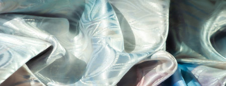 Close-up of elegant iridescent fabric with a delicate floral motif, with soft light reflecting...