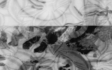 Grayscale fabric with flowing folds and an intricate, abstract pattern, emphasizing the soft, elegant texture of the material.の写真素材