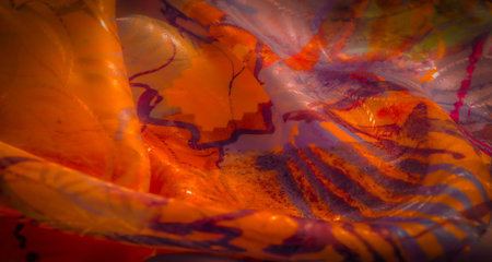 Colorful abstract fabric with a blend of yellow, orange, red, and purple hues. The texture is soft...